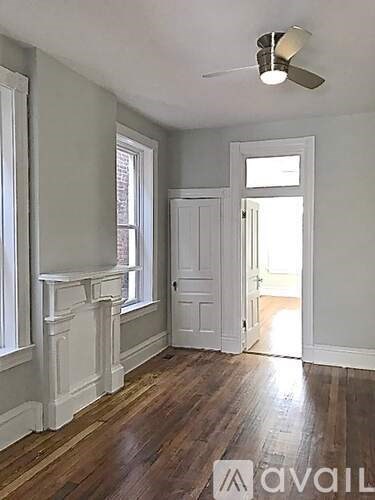 A room with a wooden floor and a ceiling fan.