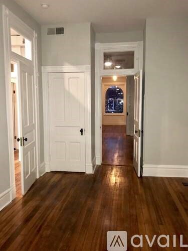 A hallway with wooden floors and white doors.