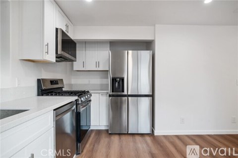 A kitchen with white cabinets and stainless steel appliances.