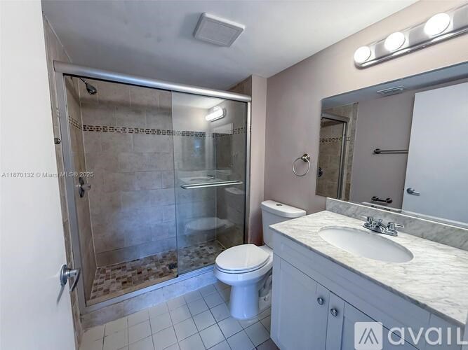 A bathroom with a walk-in shower, toilet, and sink.