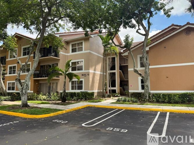 Apartment complex with a parking lot in front.