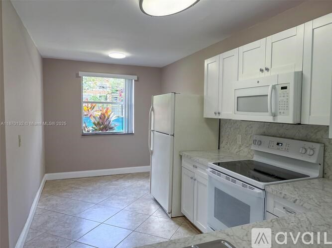 A kitchen with white appliances and cabinets.