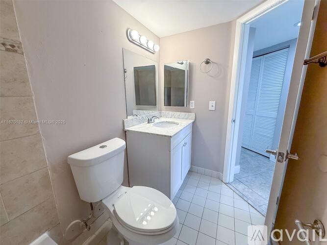 A white toilet with a white sink and a mirror above it.