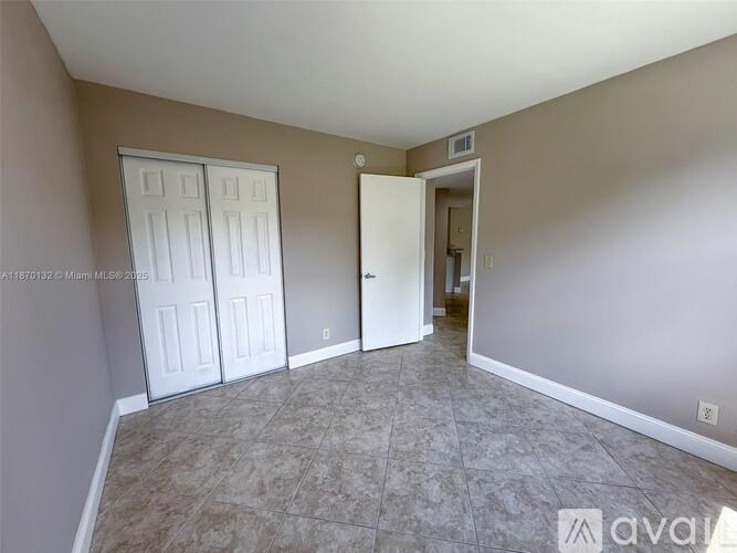 A room with a tiled floor and two white doors.