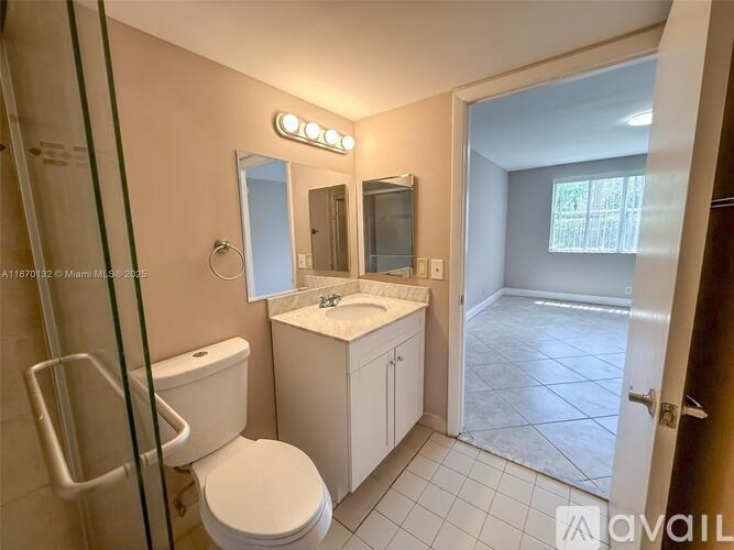 A bathroom with a toilet, sink, and mirror.