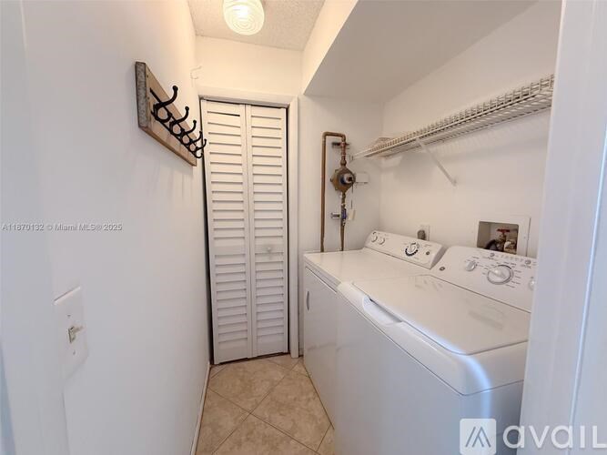 A small laundry room with a washer and dryer.