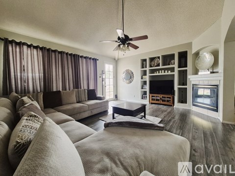A living room with a grey sofa and a black coffee table.