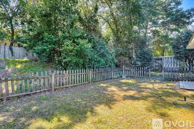 A backyard with a wooden fence and trees.