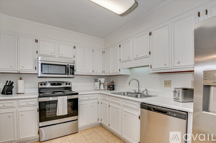 A kitchen with white cabinets and stainless steel appliances.