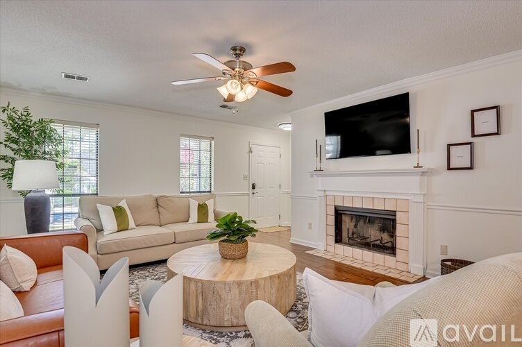 A living room with a fireplace and a television on the wall.