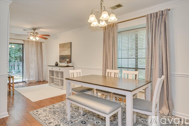 A dining room with a table and chairs.