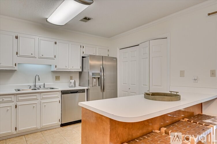 A kitchen with white cabinets and a refrigerator.