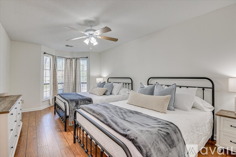 A bedroom with a large bed and a ceiling fan.