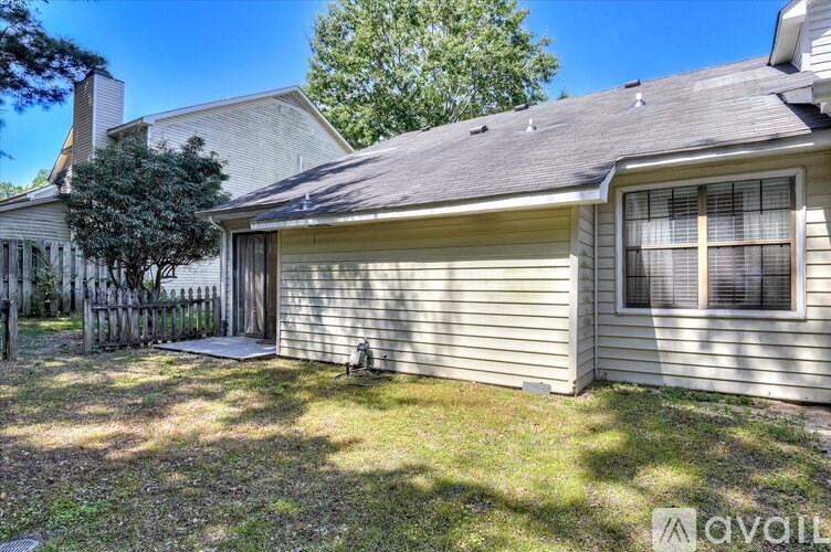 A house with a grey roof and a tree in front of it.