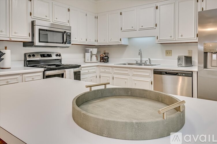 A kitchen with white cabinets and a large island.