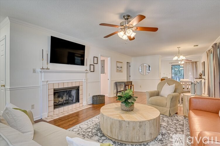 A living room with a fireplace and a flat screen TV mounted above it.