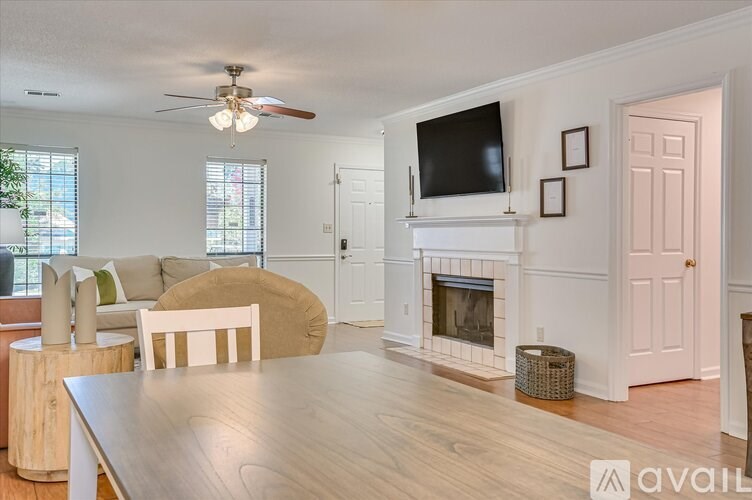 A living room with a fireplace and a television mounted above it.