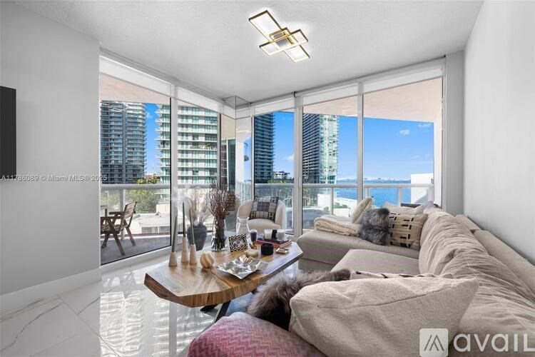 A living room with a large window overlooking a cityscape.