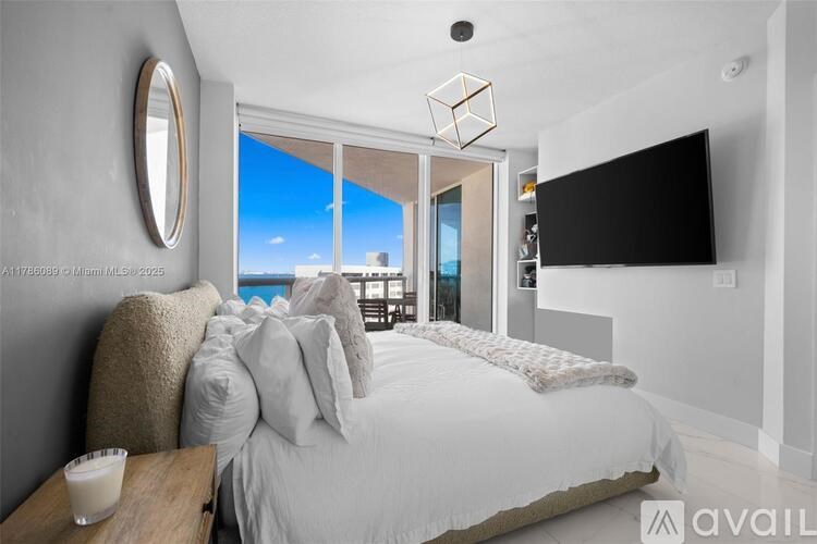 A bedroom with a large bed and a flat screen TV mounted on the wall.