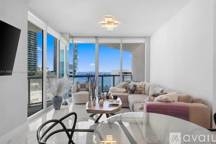 A modern living room with a glass table and a view of the city.