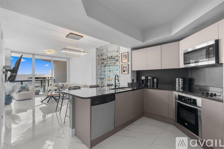 A modern kitchen with a large island and stainless steel appliances.