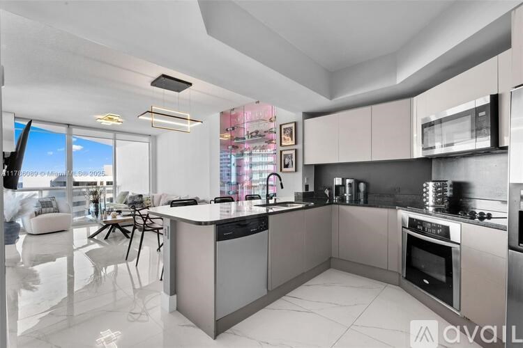 A modern kitchen with a large island and stainless steel appliances.