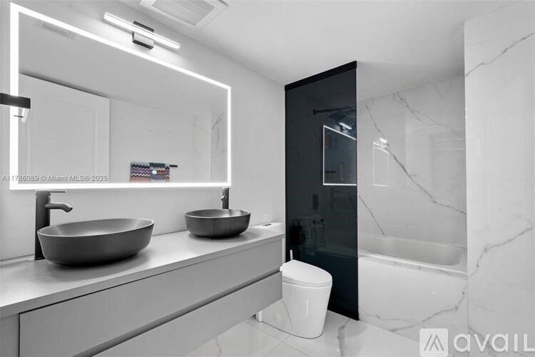 A bathroom with a marble countertop and a large mirror.