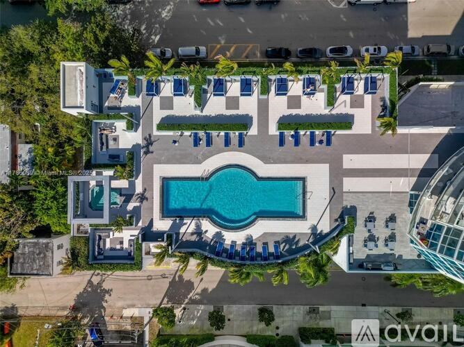An aerial view of a resort with a swimming pool and lounge chairs.