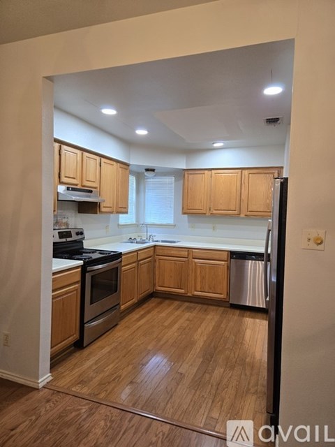A kitchen with wooden cabinets and a black refrigerator.