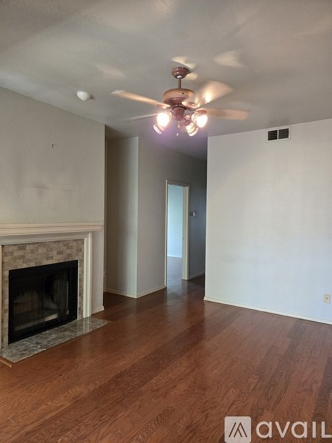A room with a fireplace and a ceiling fan.
