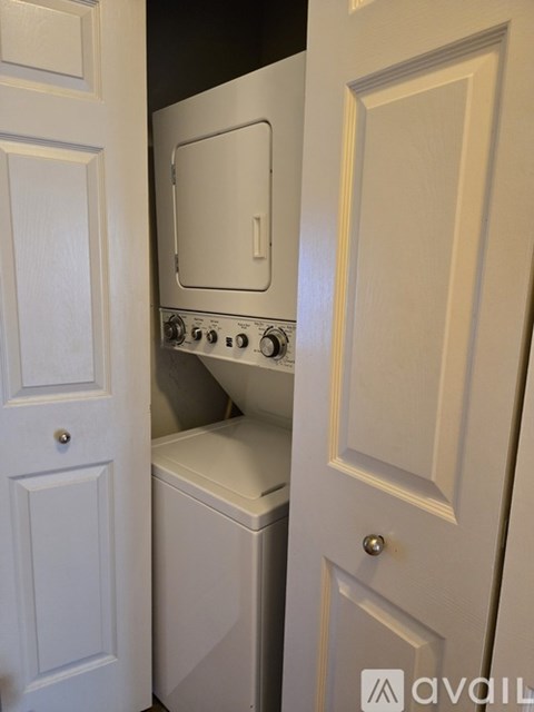 A white oven and dishwasher are built into a cabinet.