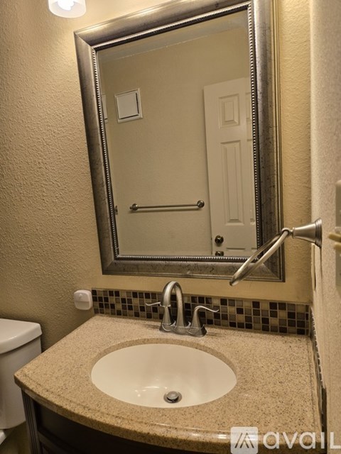 A bathroom with a sink, mirror, and toilet.