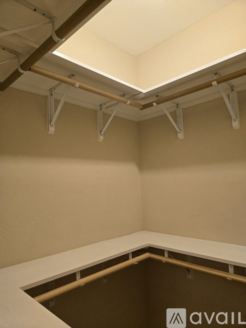 A room with a brown floor and white walls with a ceiling light.