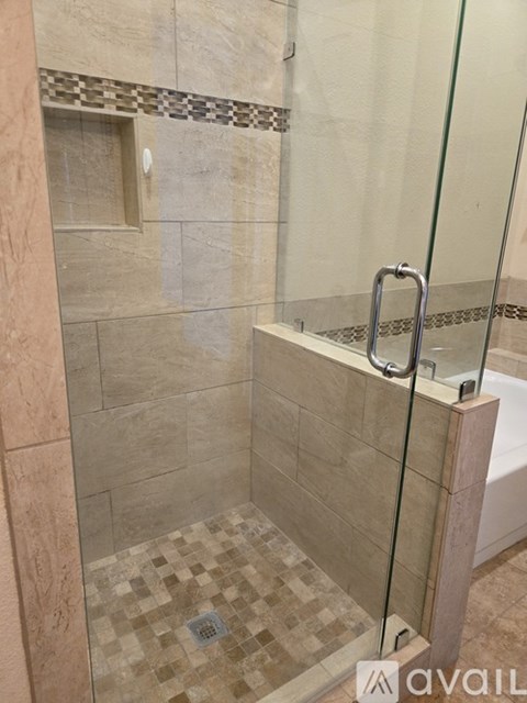 A tiled shower area with a glass door.