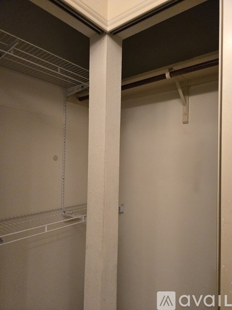 A white closet with a shelf and a hanging rod.