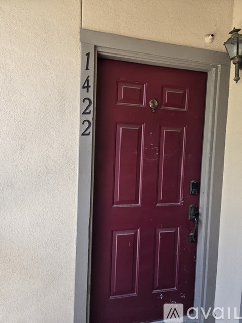 A red door with the number 1422 on the wall above it.