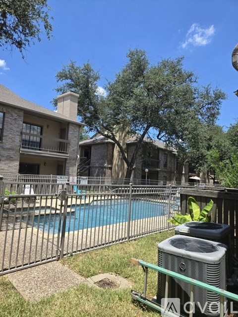 A pool and a tree are visible behind a fence.