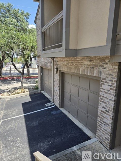 A black asphalt driveway leads to a garage door.