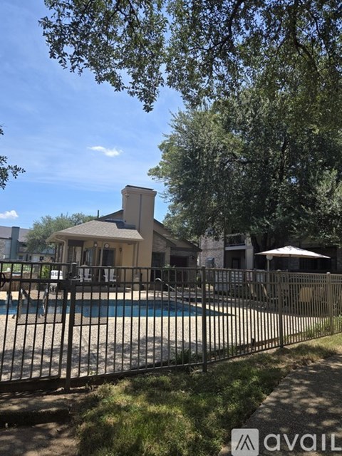 A house with a pool and a fence in front of it.