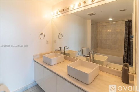 A bathroom with two sinks and a large mirror.