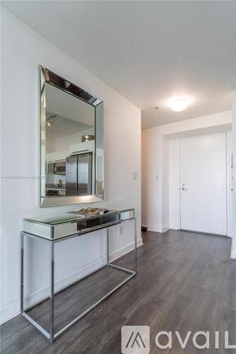 A vanity table with a mirror is in a room with wooden floors.