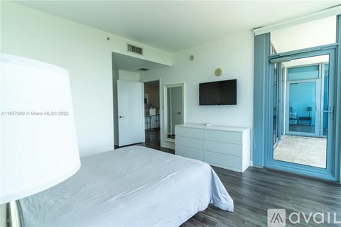 A bedroom with a bed, dresser, and mirror.