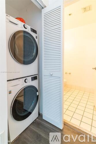 A white washing machine is in a small room.