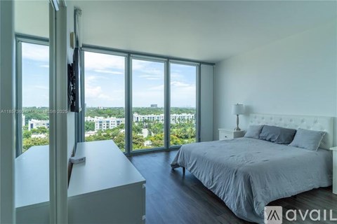 A bedroom with a large bed and a view of the city.