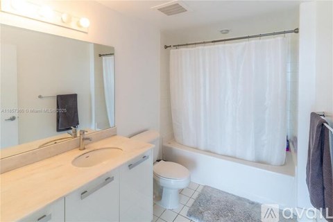 A bathroom with a toilet, sink, and shower.
