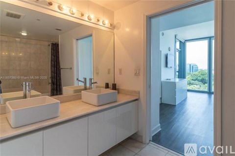 A bathroom with two sinks and a large mirror.