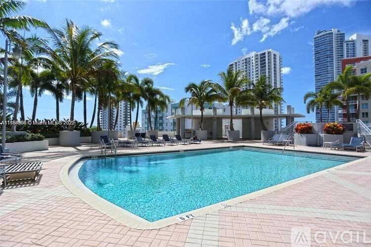A pool surrounded by palm trees and lounge chairs.