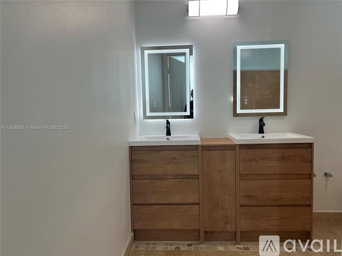 A bathroom with two sinks and a large mirror.