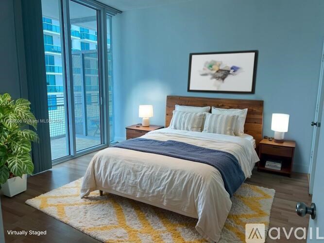 A bedroom with a bed, two lamps, and a painting on the wall.