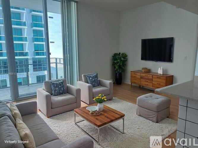 A living room with a couch, chairs, a coffee table, and a television.